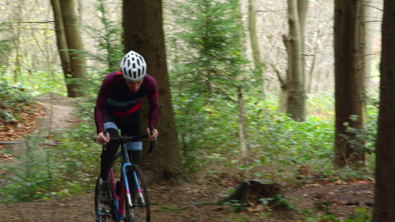 Giovane uomo in mountain bike nella foresta, vista frontale, ripreso con R3D