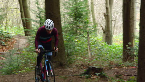 young man cross-country cycling in forest, front view, shot on r3d