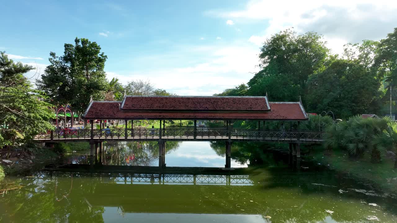 Covered pedestrian bridge crosses Siem Reap river in Cambodia, aerial