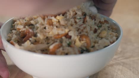 close slider shot of cleaning the sides of a white bowl of fried rice