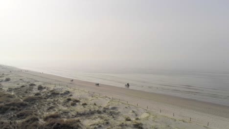 Vista-Aérea-Que-Muestra-Una-Interminable-Playa-De-Arena-Con-Un-Turista-A-Pie-Por-La-Mañana