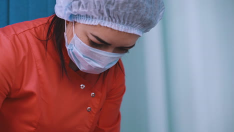 medical worker in uniform and protective mask works in room