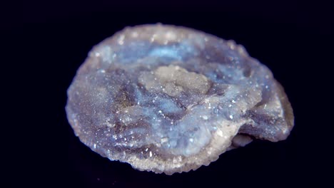 seamlessly rotating a blue mineral (chalcedone rose) in front of black background