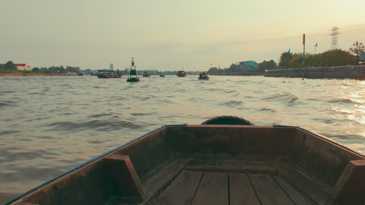 A boat drifting along a river in Vietnam, surrounded by other vessels and scenic views
