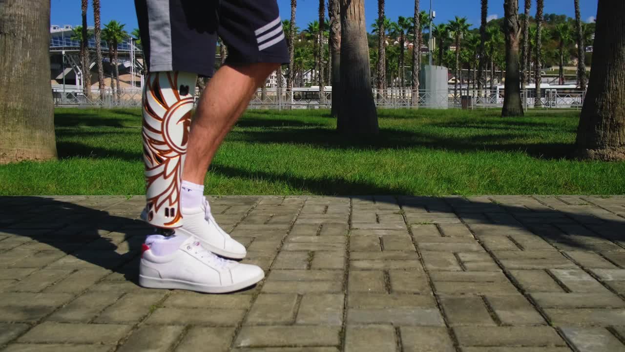 hombre con pierna protésica caminando en un parque cerca del aeropuerto