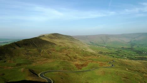 drone shot from the top of mam tor looking over winnats pass, peak district panning right and moving towards the road showing moving cars and mountains