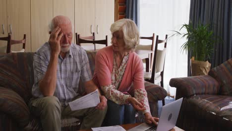 pareja mayor en el distanciamiento social usando computadora portátil