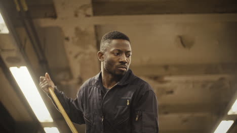 Janitor-dancer-pushes-mop-and-looks-sorrowful,-low-angle-medium-closeup