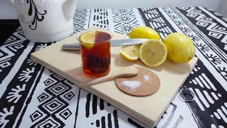 preparing green tea with lemon wedges. on wooden cutting board.