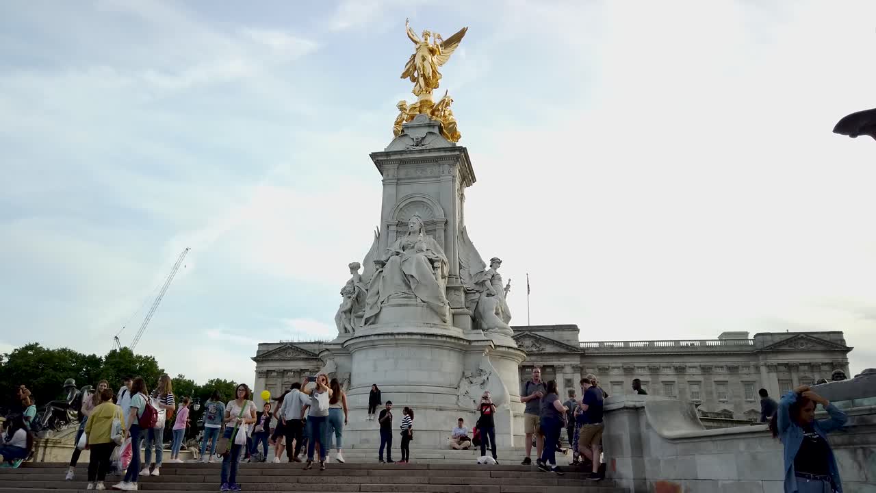 People gather around the Victoria Memorial outside Buckingham Palace in London