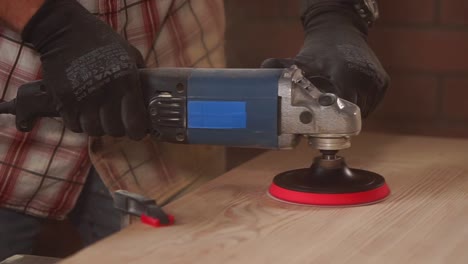 pulir una superficie de madera con una lijadora eléctrica