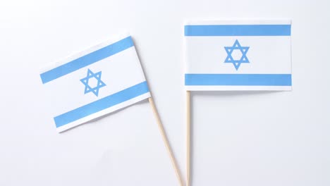 close up of two flags of israel lying on white background