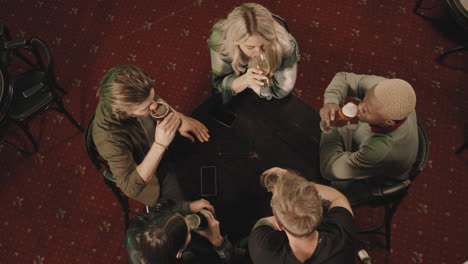 company of friends relaxing in pub