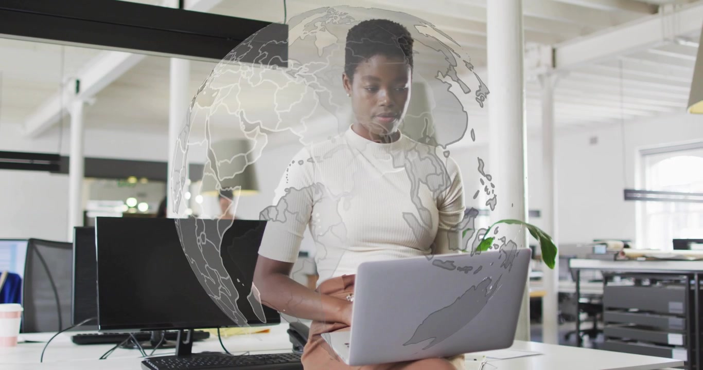 Coworker typing on laptop in business office and activating world map evolving into rotating globe
