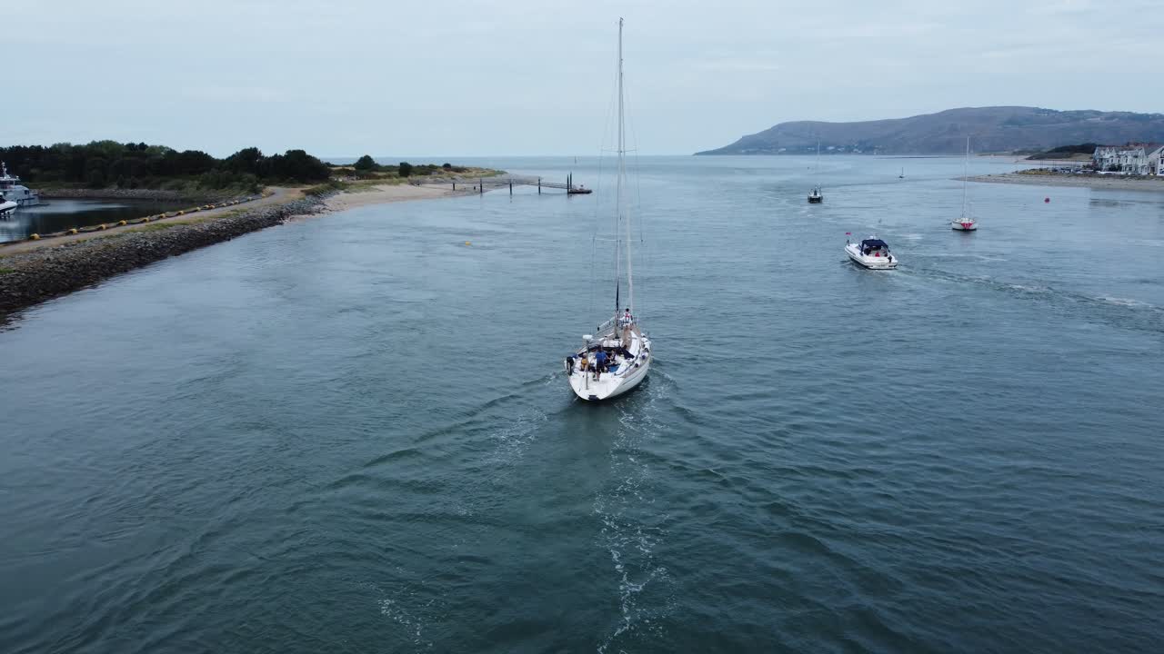 vista aérea siguiendo detrás de un velero de lujo viajando a lo largo del pintoresco estuario del río.