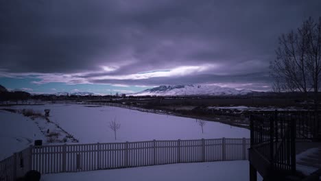 Stormy-sky-over-a-winter-landscape-in-a-snowy-suburban-neighborhood---cloudscape-time-lapse