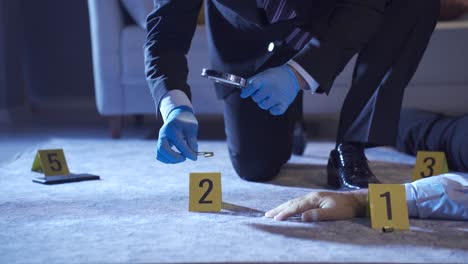 the criminologist examines the evidence at the crime scene. bullet casings.