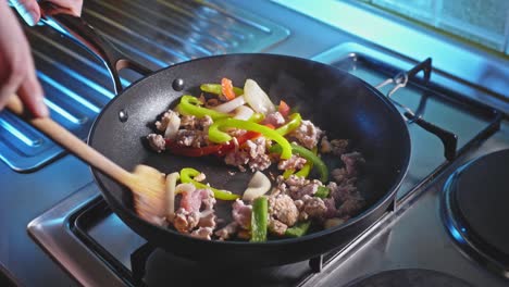 cooking and stirring ground turkey with bell pepper and onion