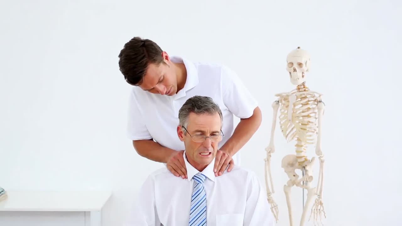 fisioterapeuta dando a un hombre de negocios un masaje en el hombro