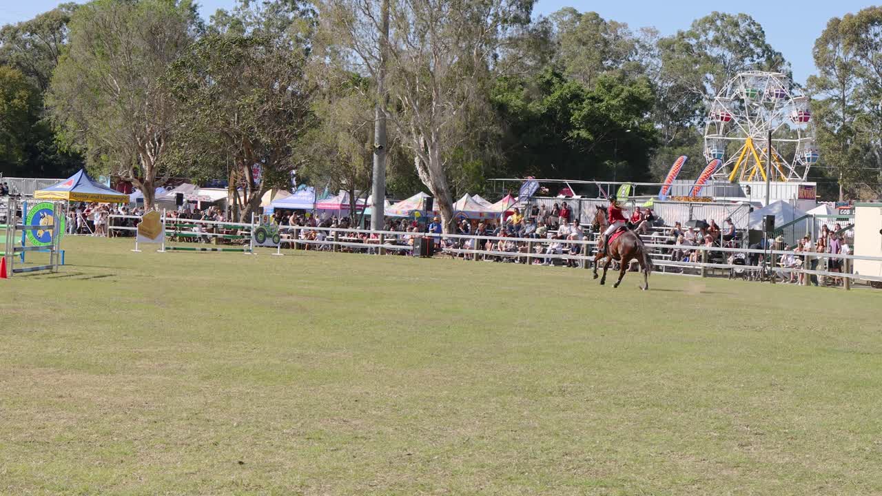 Horse and rider navigating jump course at fair