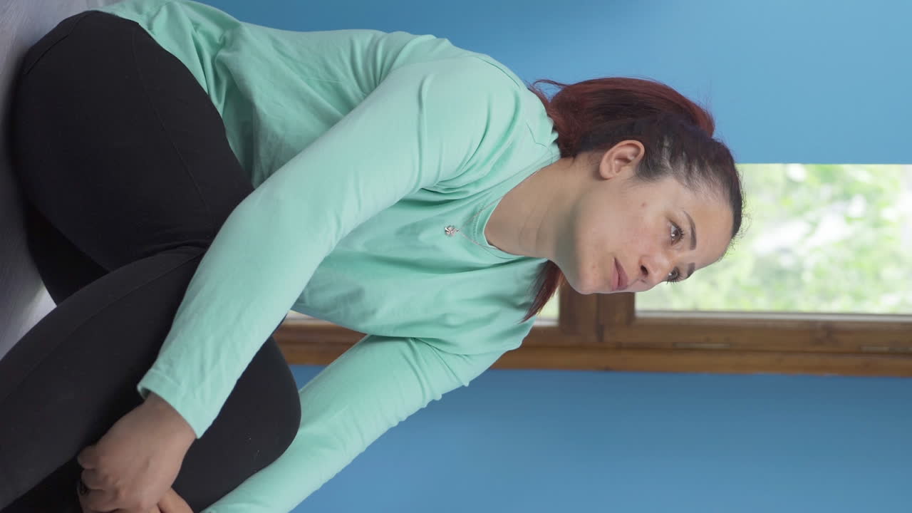 벽  ⁇ 에 앉아 있는 스트레스와 긴장의 수직 비디오입니다.