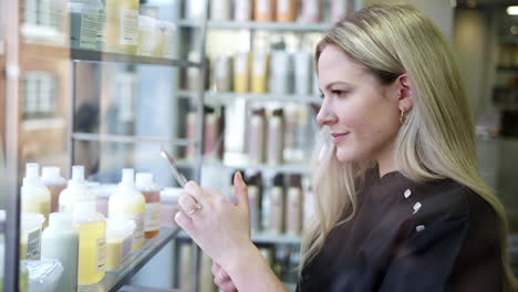 female business owner in hairdressing salon with digital tablet checking beauty products