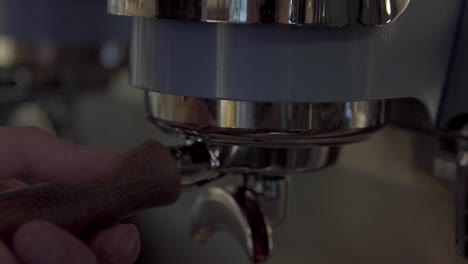 Hand-Inserting-Portafilter-With-Coffee-To-Coffee-Machine,-close-up,-slow-motion