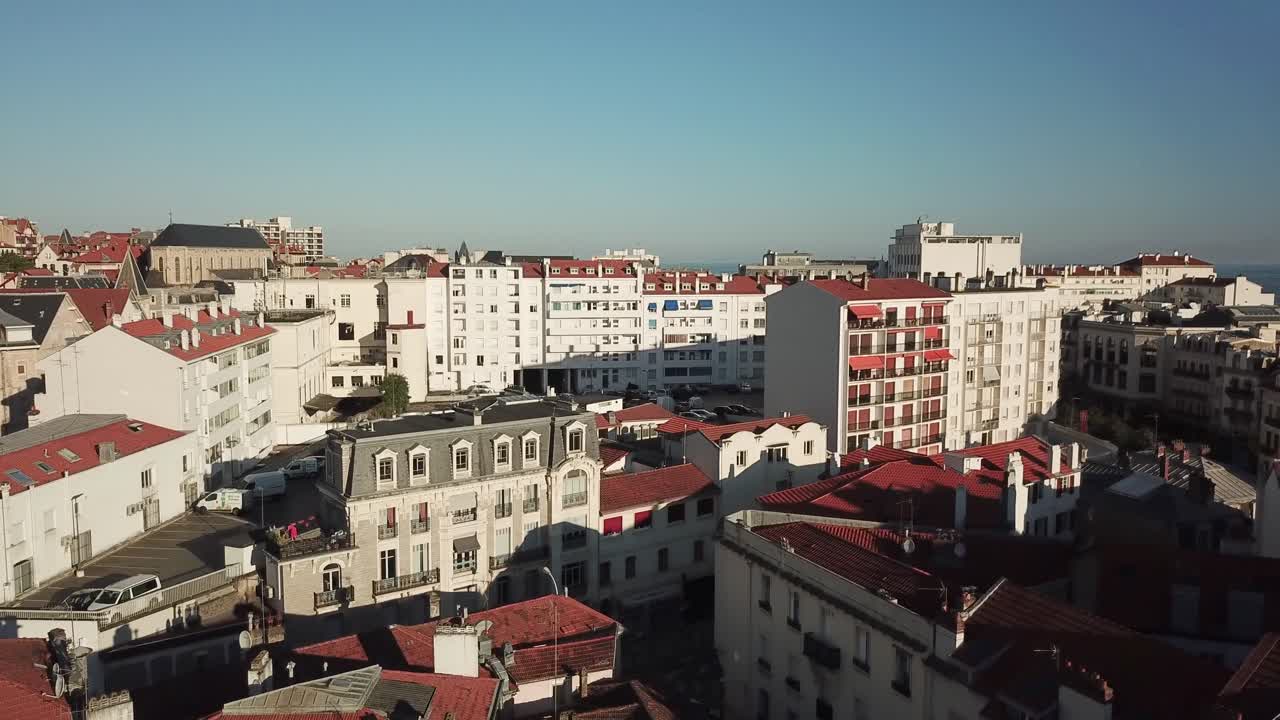 Drone che si alza sopra i tetti della città di Biarritz con il mare sullo sfondo, Francia