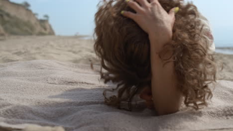 Una-Mujer-Sonriente-Se-Divierte-Rodando-En-La-Playa-De-Arena-De-Cerca.-Chica-Tumbada-En-La-Costa.