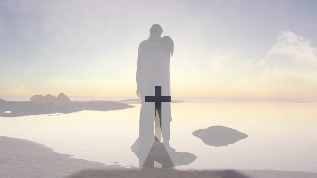 Embracing couple on serene beach with cross animation overlay in background