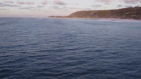 A-serene-view-of-the-North-Shore-of-Hawaii,-showcasing-the-vast-ocean-and-coastal-landscape-during-a-peaceful-sunset