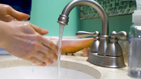 tap turned on and hands washed over sink with water running