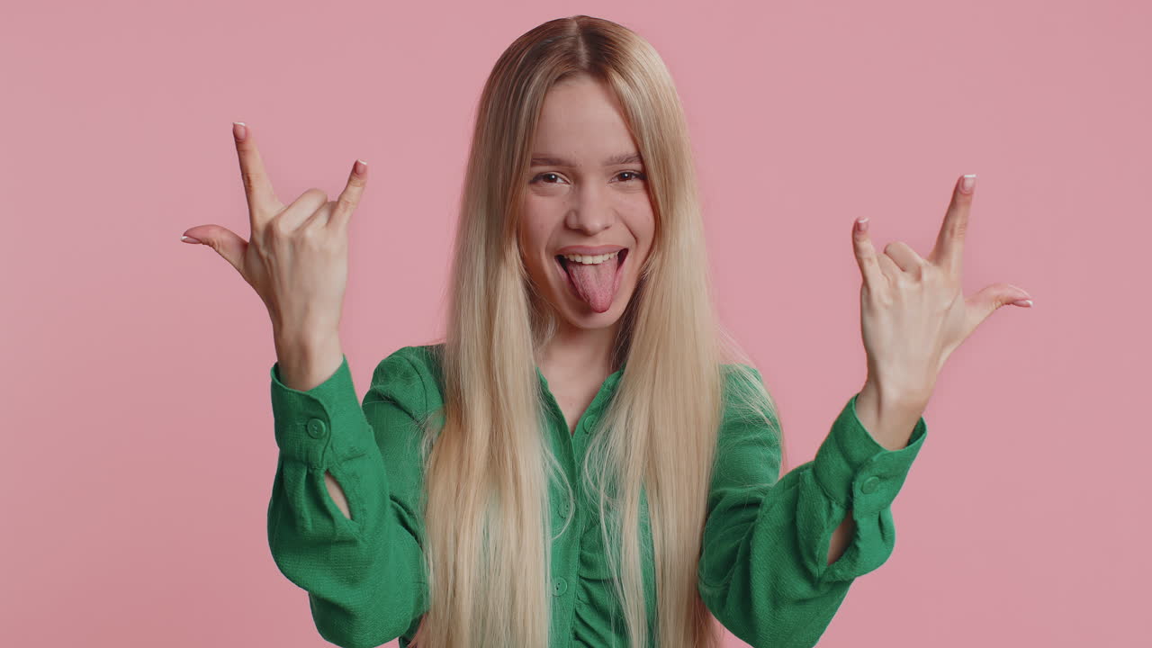 Donna caucasica che mostra un gesto rock'n'roll con le mani un segno freddo un'espressione pazza ballando festeggiando