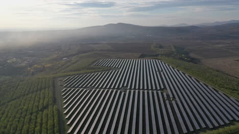 Vista-Aérea-Volando-Sobre-La-Granja-De-Paneles-Solares-En-Un-Día-Soleado,-El-Futuro-De-La-Energía-Renovable-Verde