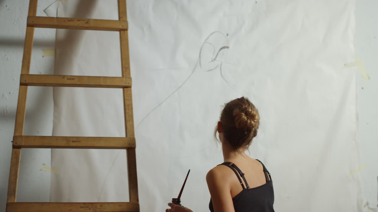 mujer inspirada trabajando en un estudio de arte. pintora creativa haciendo borradores en lienzo.