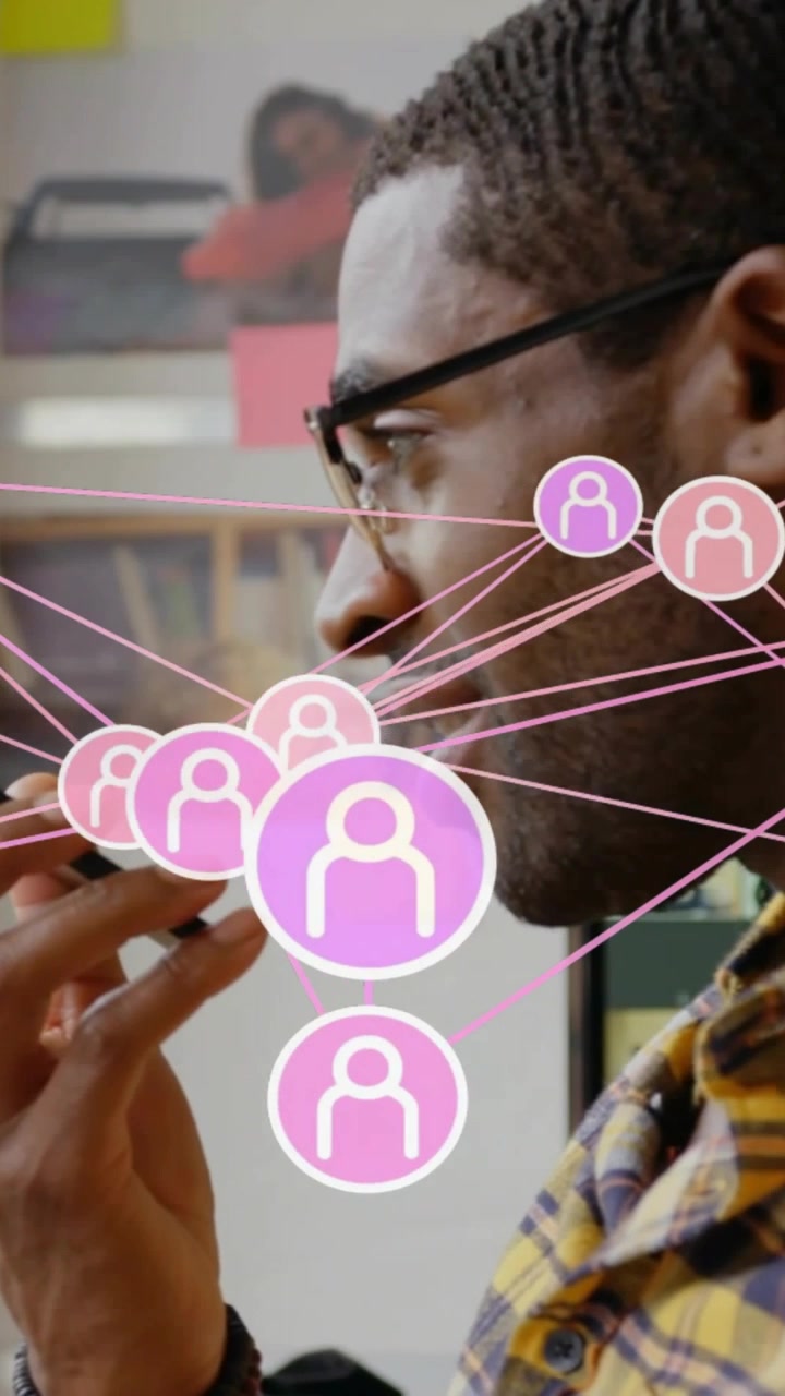 Vertical video: Man speaking into smartphone at work, causing business network overlay across face
