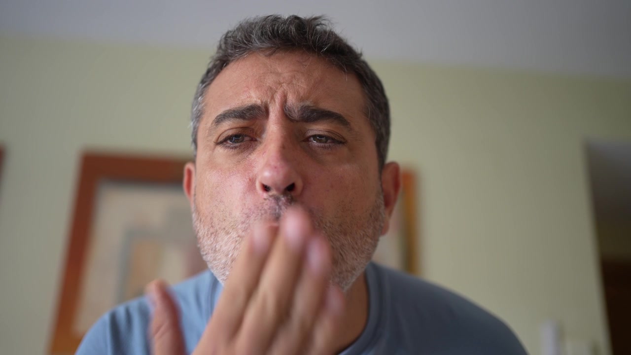 Expressões de afeto: um close-up de um homem soprando beijos doces suavemente.
