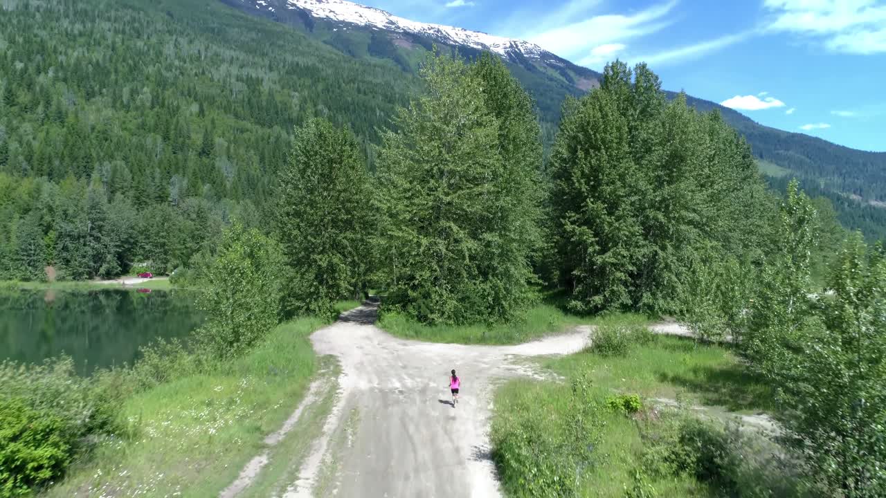 Female jogger running on the forest path 4k