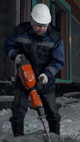 construction worker using jackhammer in winter