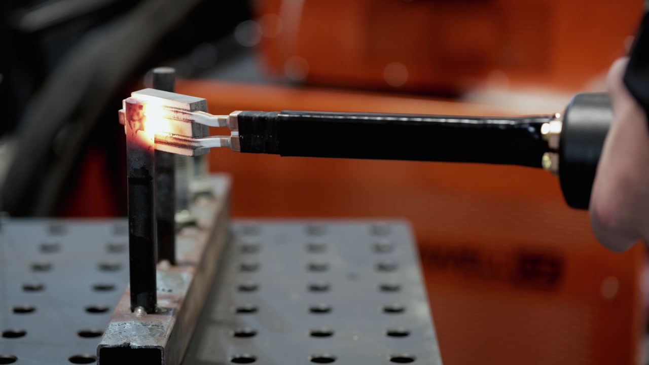 Saldatura a resistenza industriale di componenti metallici in officina.
