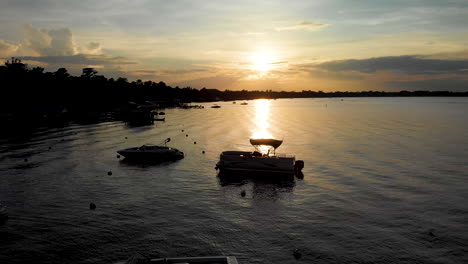 drone-shot-silhouetted-boats-on-lake-sunset