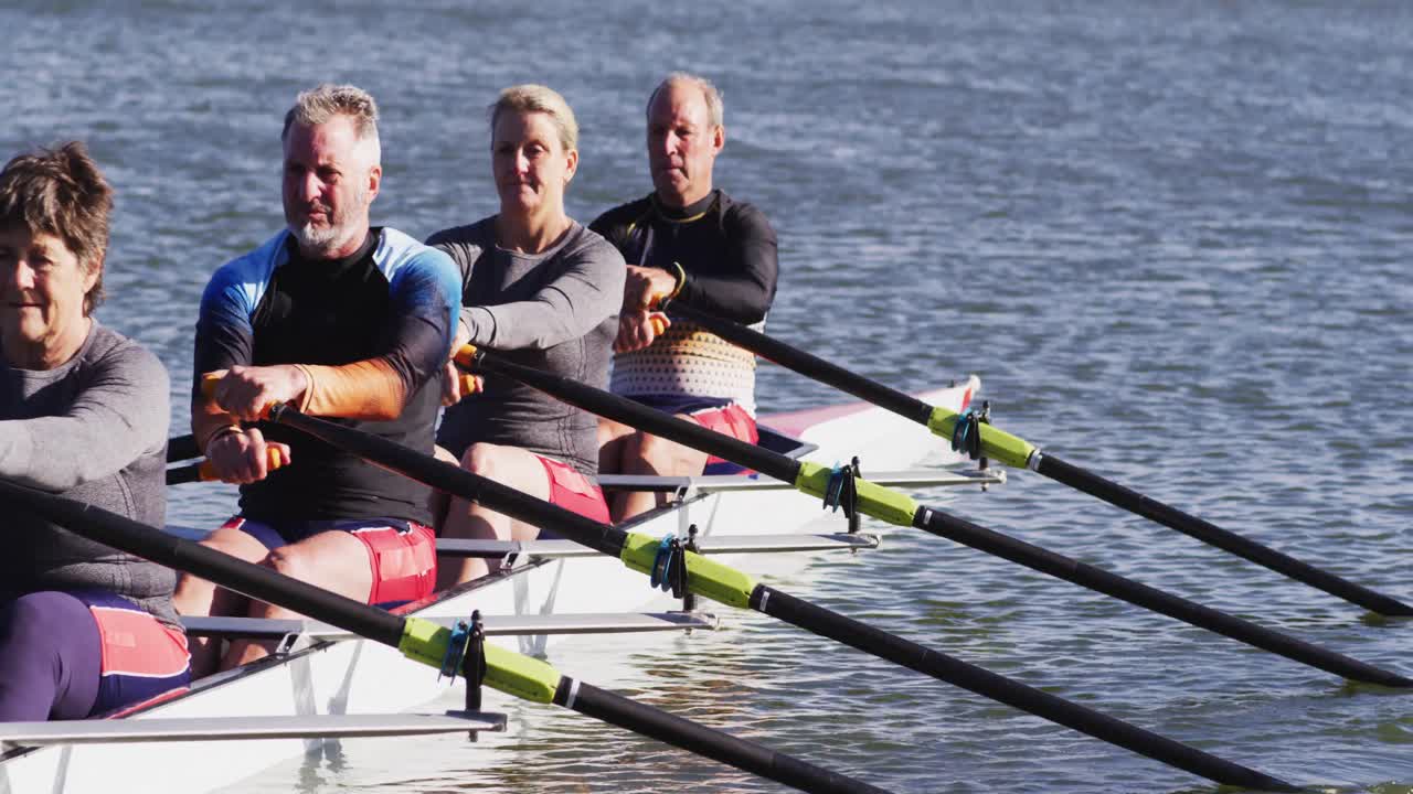 Four senior caucasian men and women rowing boat on a river