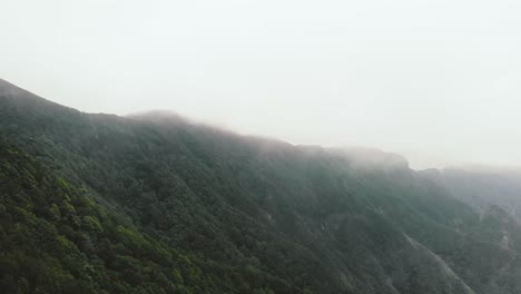 Flight-in-the-clouds-in-mountains,-morning-clouds-in-the-mountains-aerial