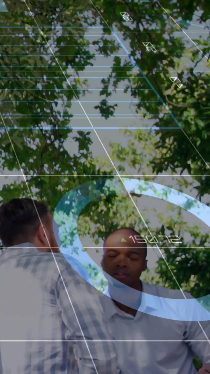 Video verticale: Squadra che tiene una riunione di lavoro all'aperto, con una panoramica della telecamera che crea anelli HUD blu sopra il tavolo.