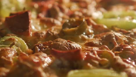 primer plano de una pizza con pepperoni y pimientos verdes