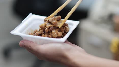 secuencia de comer natto con palillos de un cuenco