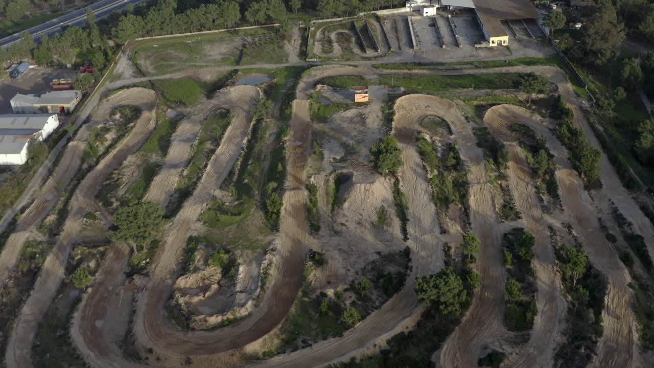 pista de motocross en el bosque cerca de una carretera y una zona poblada
