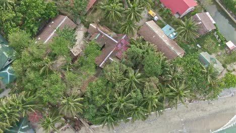 Aerial-shot-of-houses-on-front-the-beaches-from-Puerto-Galera,-Philippines