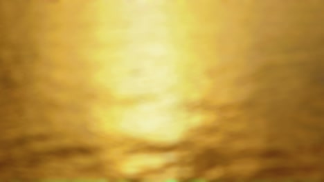 sunset  - seamless loop of a completely defocused 4k-shot of a slightly wavy water surface. the sun is low and the reflected light is shimmering on the water surface