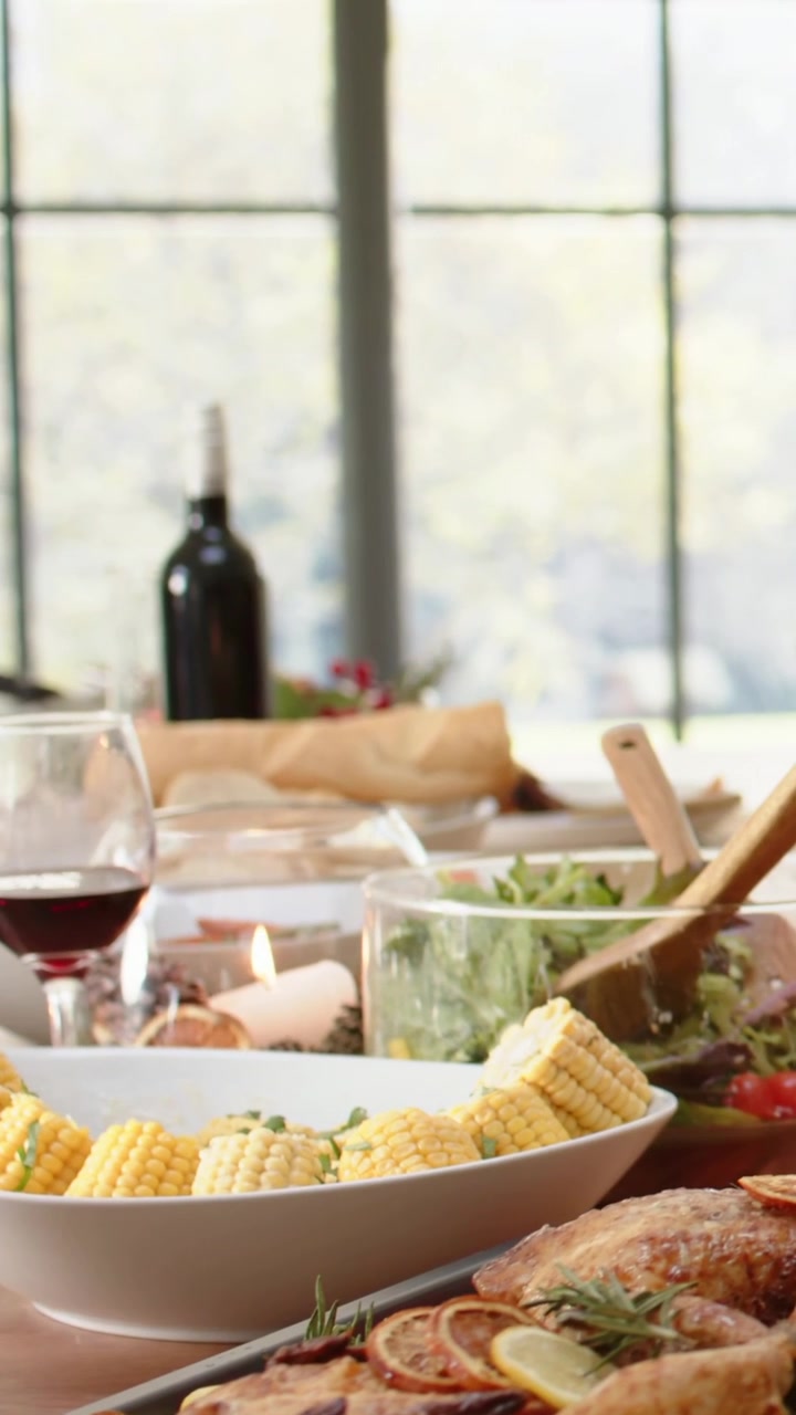 Vertical video: Reaching hand in grey sweater steadying glass serving salad by window for sharing